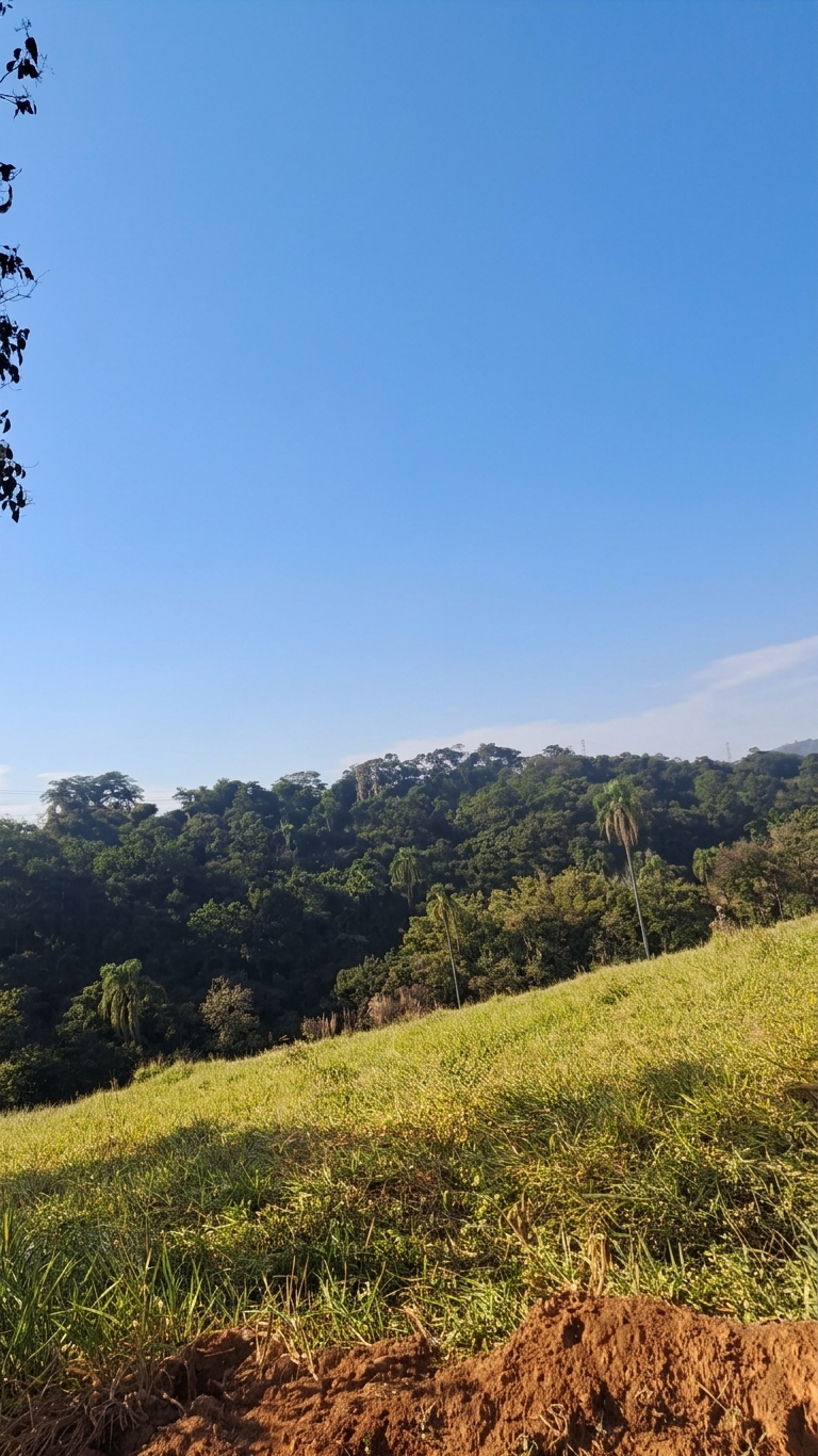 Operador inicia a medição com o gps de alta precisão em meio a uma bela paisagem de pasto e céu azul.